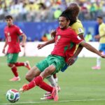 لاعب مغربي يمسك لاعبًا برازيليًا.