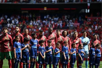 لاعبو المنتخب المغربي على أرضية الملعب بقمصان زرقاء.