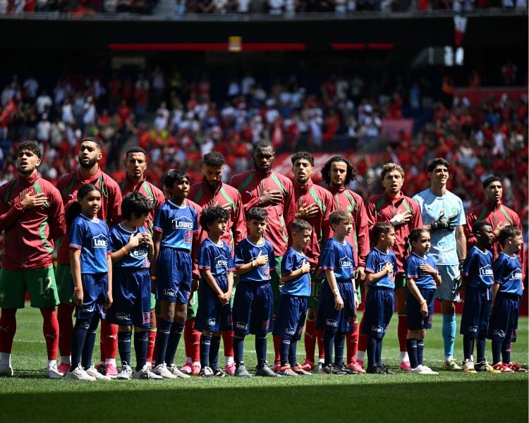 لاعبو المنتخب المغربي على أرضية الملعب بقمصان زرقاء.