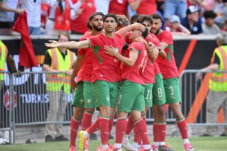 لاعبون مغاربة يحتفلون في مباراة كرة قدم.