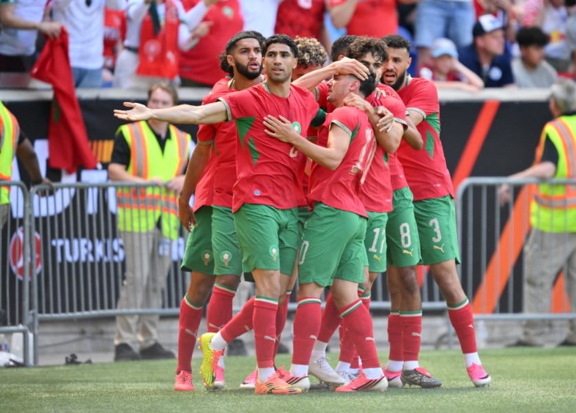 لاعبون مغاربة يحتفلون في مباراة كرة قدم.