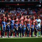 لاعبي المنتخب المغربي بقمصان زرقاء مع كلمة "حملات" ينتظرون في الملعب