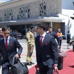 مسؤولون مغاربة يمرون عبر ممر شرفي في مطار.
