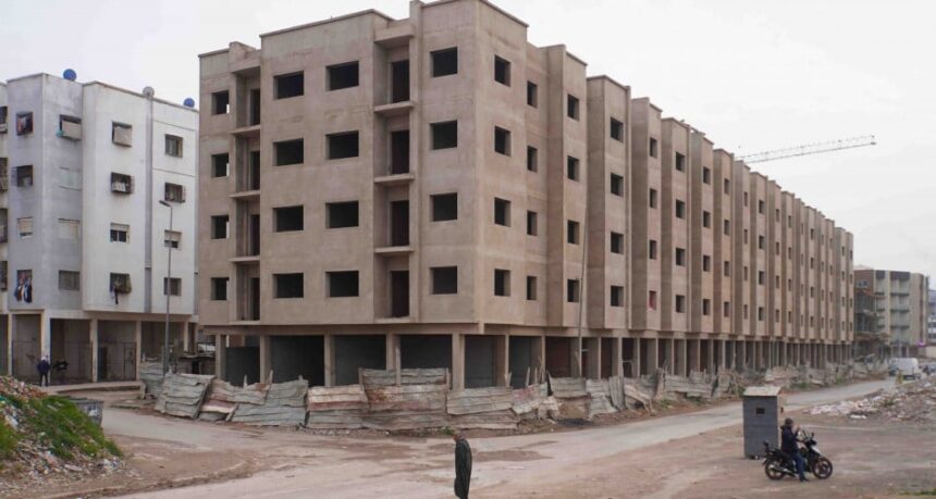 شخص يقوم بمسح منطقة بناء سكنية.
