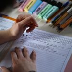شخص يقوم بملء استمارة باستخدام عدة أقلام رصاص