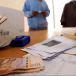 شخص يحمل 100 درهماً مغربياً مع صندوق