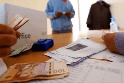 شخص يحمل 100 درهماً مغربياً مع صندوق