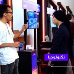رجل وامرأة يتفاعلان في مؤتمر تقني حول المدن الذكية.