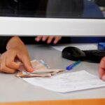 أيدٍ تتكدس فوق رزمة من الأوراق المالية.