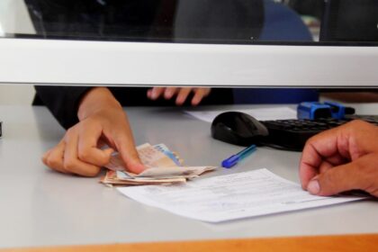 أيدٍ تتكدس فوق رزمة من الأوراق المالية.
