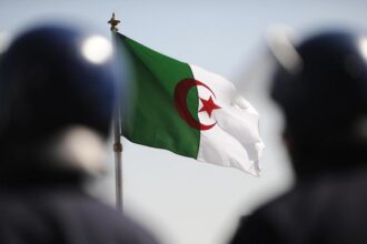 علم ممزق وشخصيات غامضة تجسد معاناة اللاجئين.
