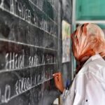 معلمة تكتب على السبورة باللغة الأمازيغية في الصف