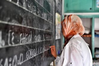 معلمة تكتب على السبورة باللغة الأمازيغية في الصف