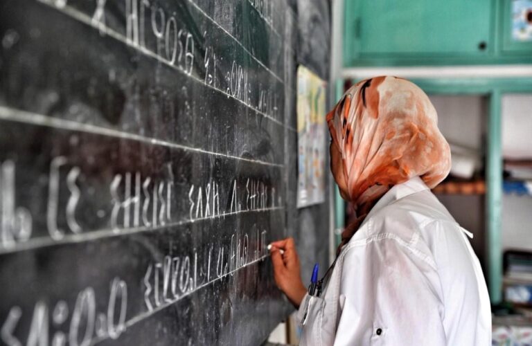 معلمة تكتب على السبورة باللغة الأمازيغية في الصف