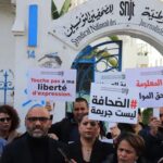 متظاهرون تونسيون يحملون لافتات بالفرنسية والعربية مطالبين بكرامة الصحفيين