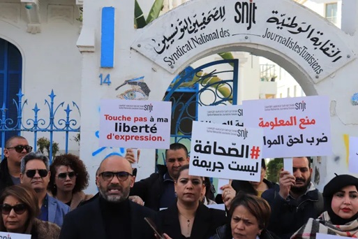 متظاهرون تونسيون يحملون لافتات بالفرنسية والعربية مطالبين بكرامة الصحفيين