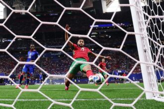 لاعب كرة قدم إفريقي يركل الكرة بقوة
