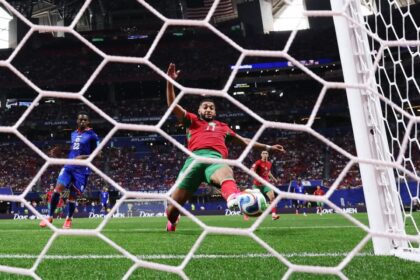 لاعب كرة قدم إفريقي يركل الكرة بقوة