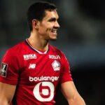 عيسى ماندي لاعب كرة قدم يحمل قميصاً أحمر.