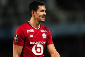 عيسى ماندي لاعب كرة قدم يحمل قميصاً أحمر.