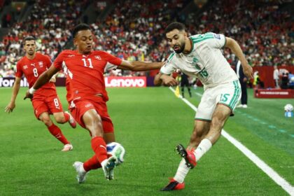 لاعب جزائري وسويسري يتنافسان على الكرة