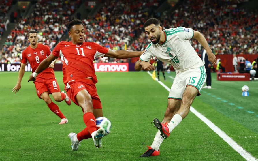 لاعب جزائري وسويسري يتنافسان على الكرة