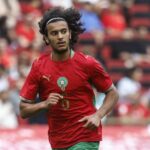 أيوب بوعدي، لاعب كرة القدم، رقم 6، يركض بقميص المنتخب المغربي.