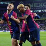 لاعبو برشلونة يحتفلون بهدف في مباراة كرة قدم.