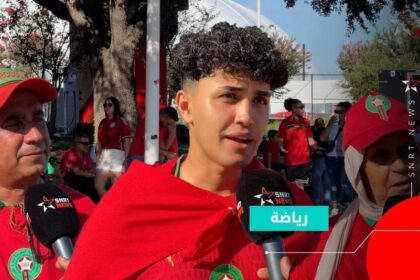 طفل يحمل شعار SNRT أمام ميكروفونات.