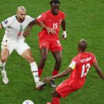 لاعب كرة قدم يرتدي القميص رقم 13 ينظر إلى الكاميرا.