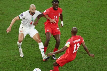 لاعب كرة قدم يرتدي القميص رقم 13 ينظر إلى الكاميرا.