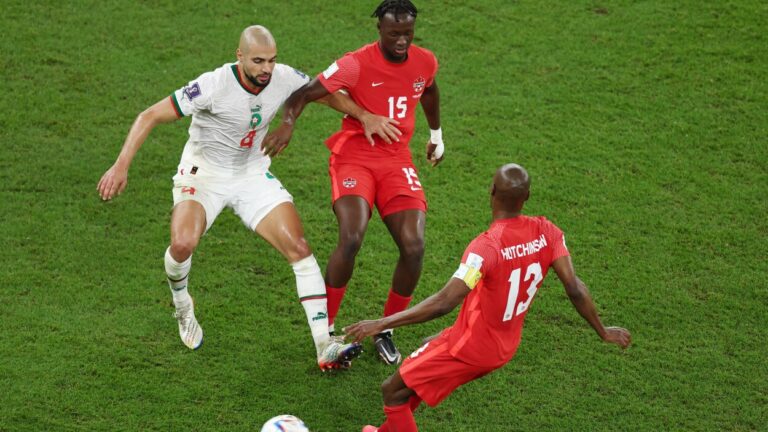 لاعب كرة قدم يرتدي القميص رقم 13 ينظر إلى الكاميرا.