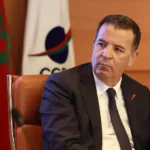 شكيب لعلج بجانب العلم المغربي