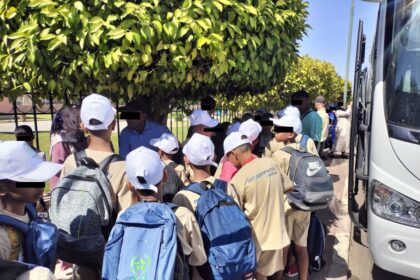 أطفال يصطفون لركوب حافلة في مخيم صيفي