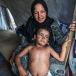 طفلان يجلسان داخل خيمة نازحين في قطاع غزة
