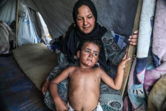 طفلان يجلسان داخل خيمة نازحين في قطاع غزة