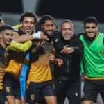 لاعب كرة قدم بالرقم 4 يعانق لاعبًا آخر بعد هدف أو فوز
