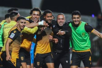 لاعب كرة قدم بالرقم 4 يعانق لاعبًا آخر بعد هدف أو فوز