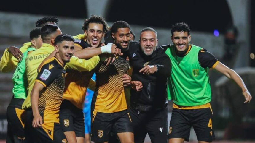 لاعب كرة قدم بالرقم 4 يعانق لاعبًا آخر بعد هدف أو فوز