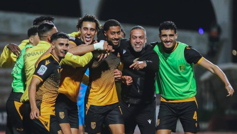 لاعب كرة قدم بالرقم 4 يعانق لاعبًا آخر بعد هدف أو فوز