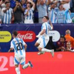 لاعب كرة قدم يركض في الملعب بزي أزرق وأبيض