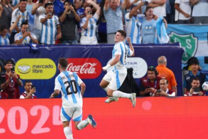 لاعب كرة قدم يركض في الملعب بزي أزرق وأبيض