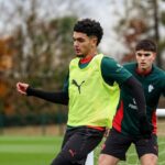لاعب كرة قدم يركض وراء آخر بقميص ميلان.