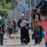 نساء فلسطينيات في مسيرة خلال نزوح جماعي