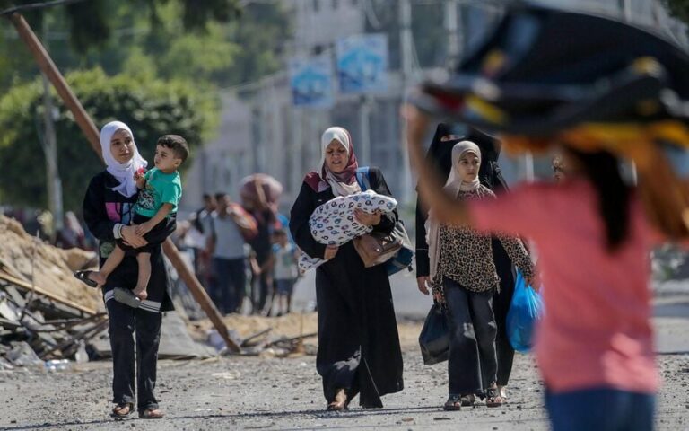 نساء فلسطينيات في مسيرة خلال نزوح جماعي
