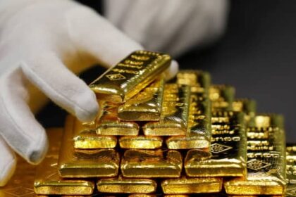 شخص يرتدي قفازات بيضاء يضع سبيكة ذهب في هرم
