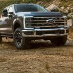 شاحنة فورد F-150 رمادية اللون تسير على طريق جبلي وعر