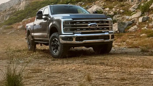 شاحنة فورد F-150 رمادية اللون تسير على طريق جبلي وعر