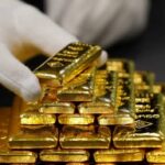 يد ترتدي قفازات بيضاء تحمل مجموعة من أحجار الياقوت الحمراء اللامعة.