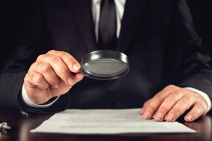 رجل أعمال يدقق في وثائق مالية عبر عدسة مكبرة